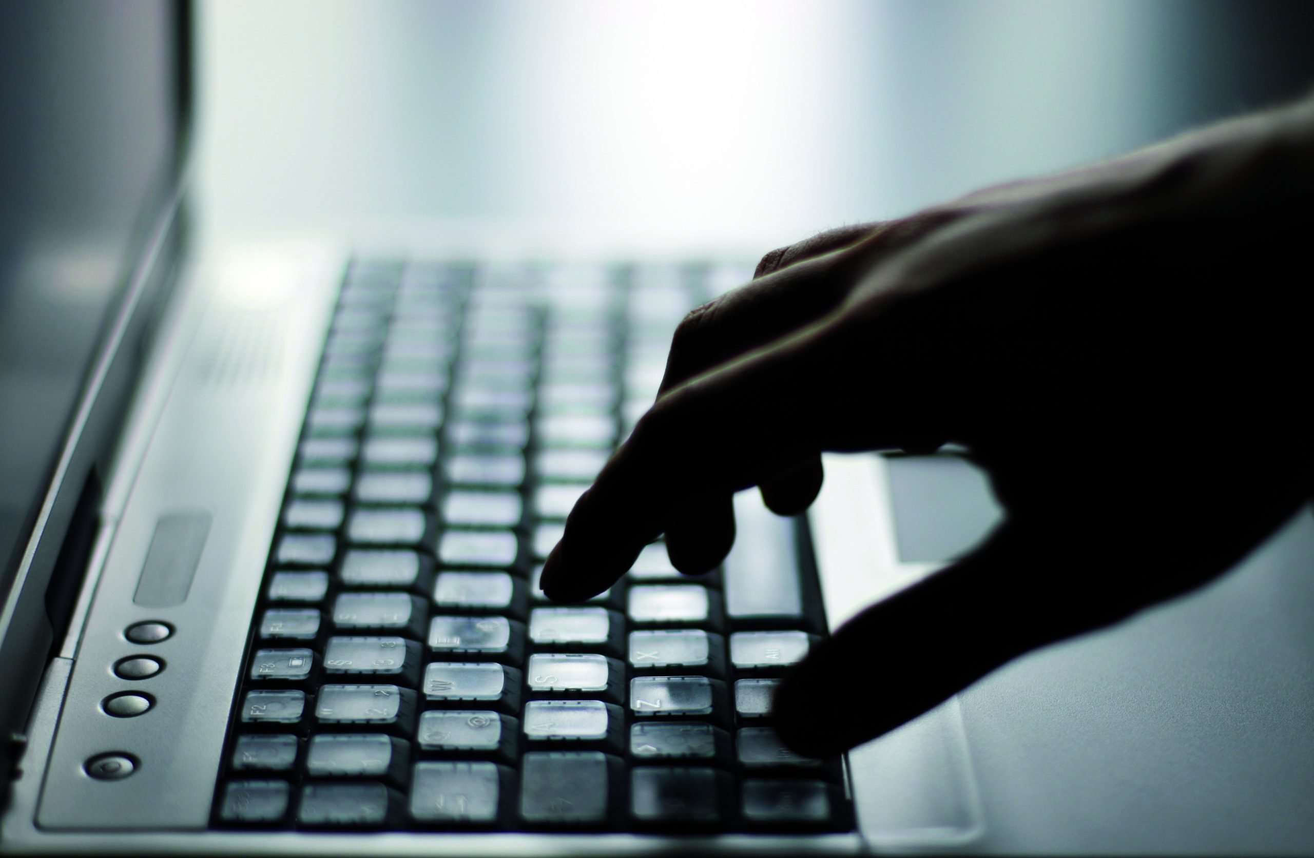mão digitando em um teclado de notebook