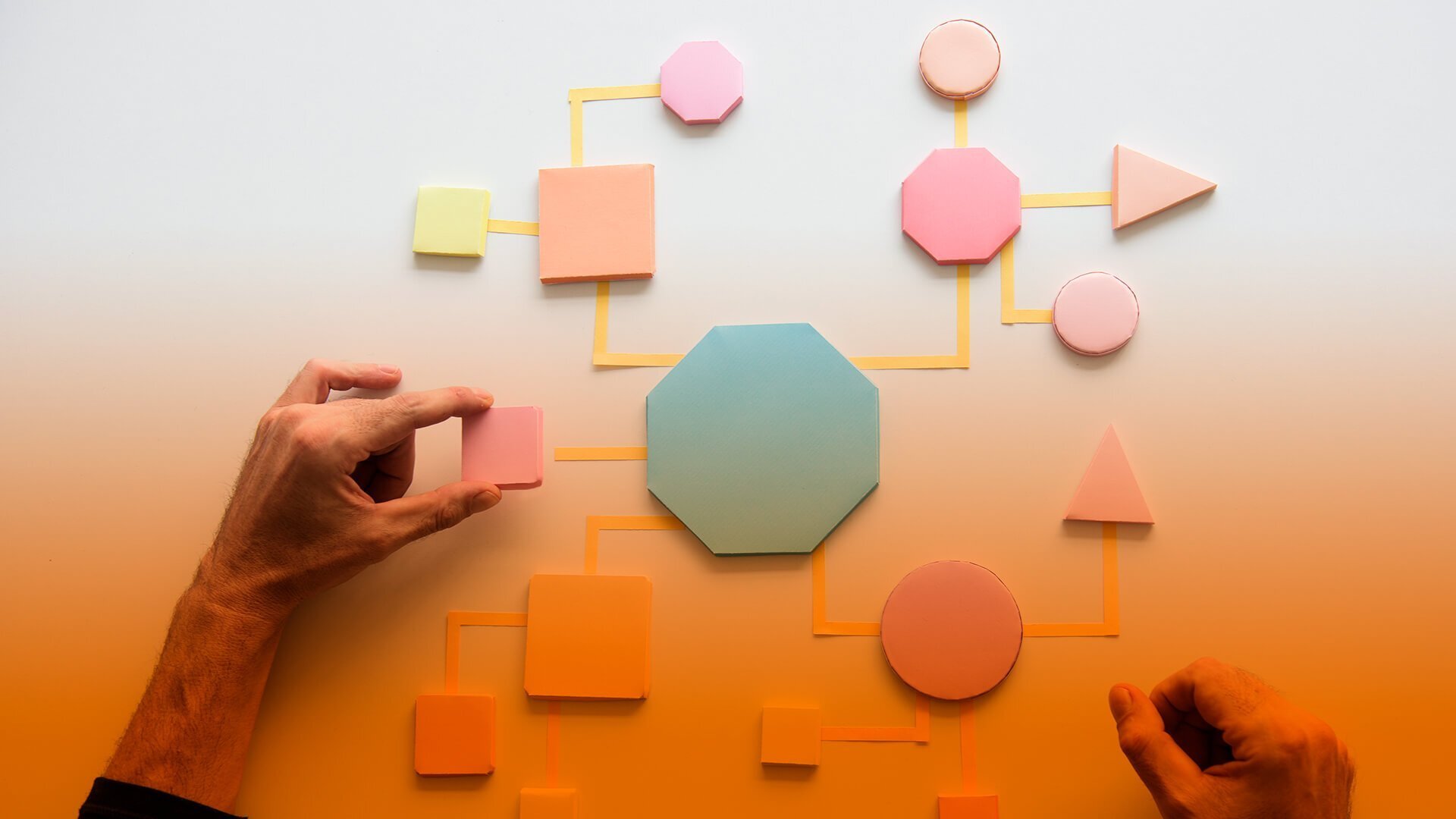 pessoa posicionando peças com formas geométricas em um diagrama