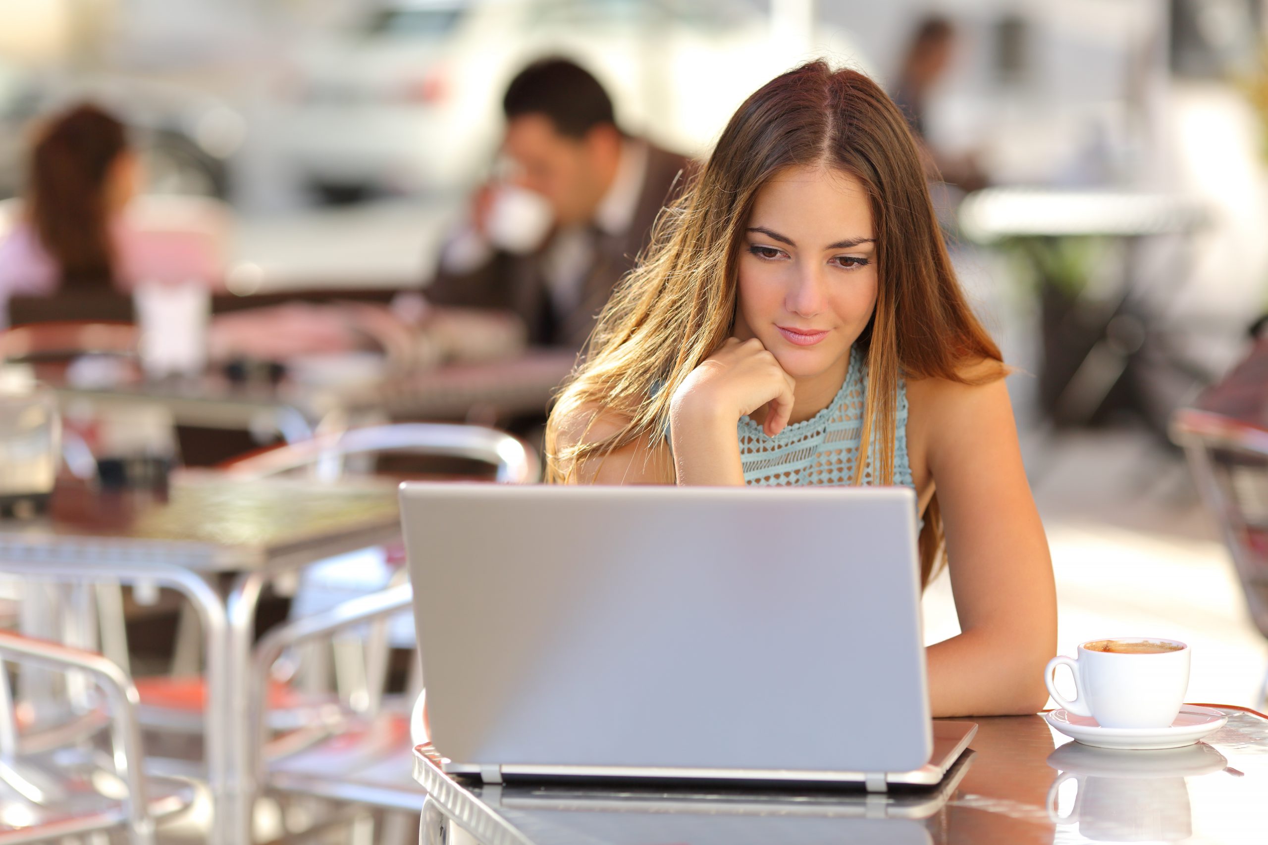 mulher jovem branca trabalhando em um notebook, em um ambiente de escritório