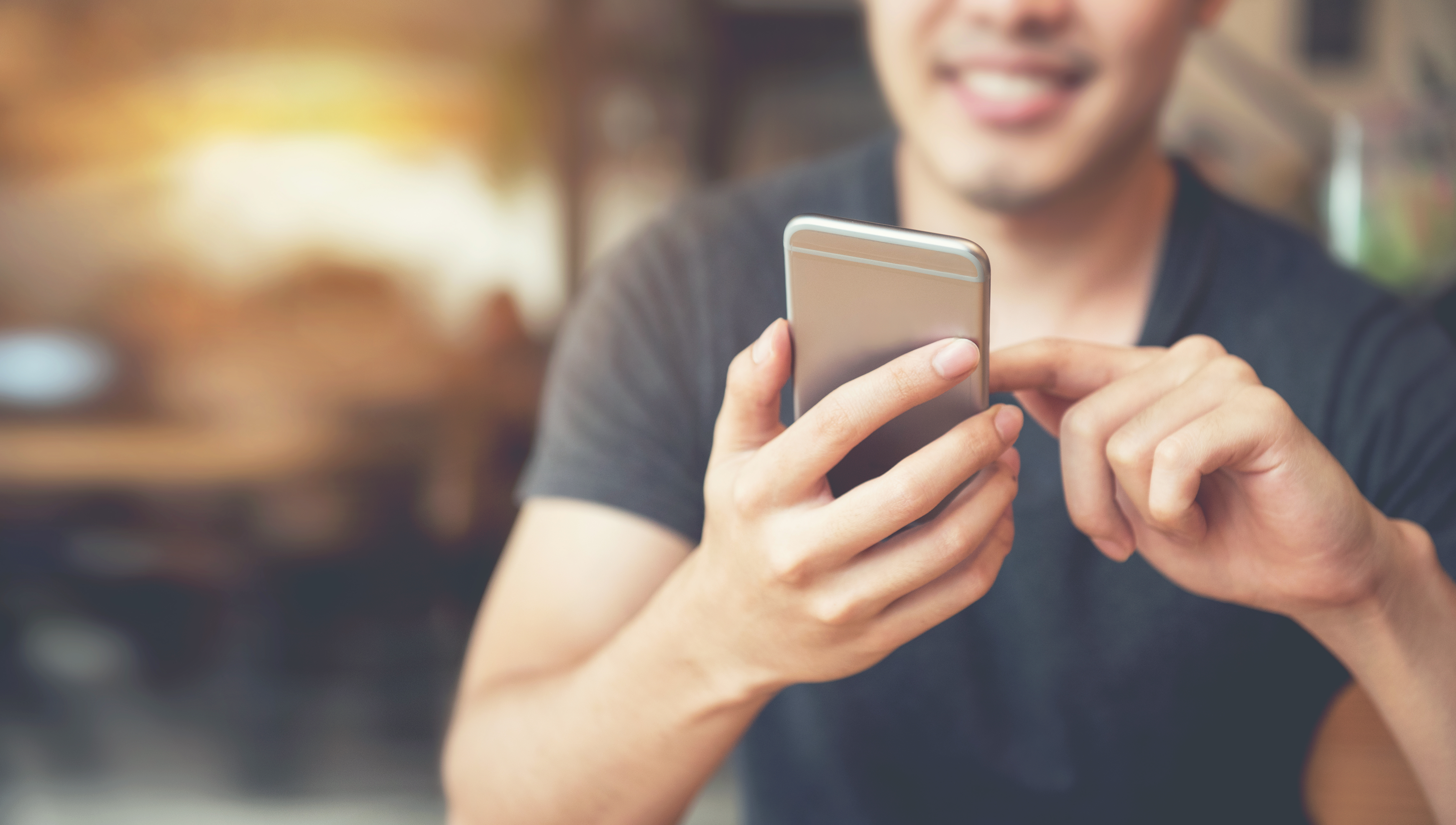 pessoa sorridente utilizando um smartphone