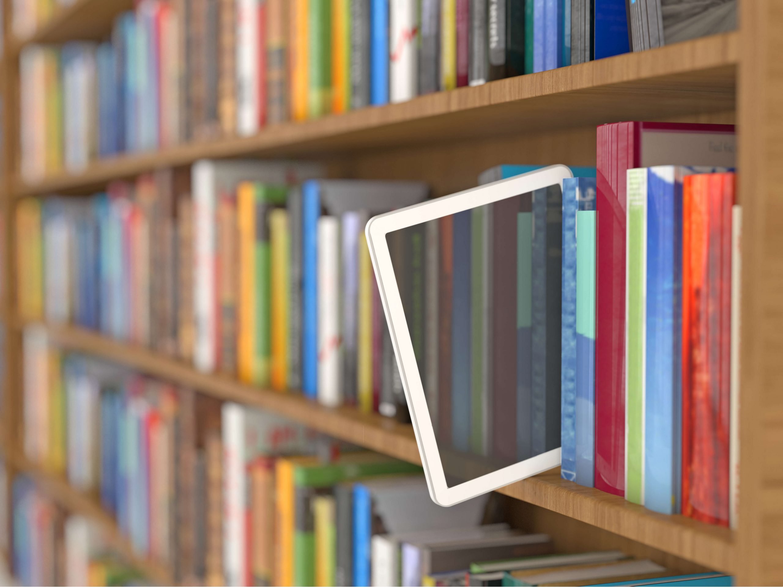 tablet em meio aos livros em uma estante