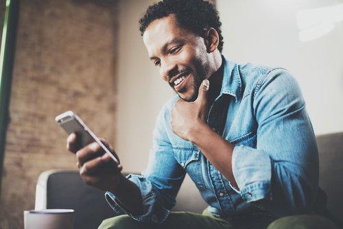 profissional jovem, negro, utilizando um smartphone